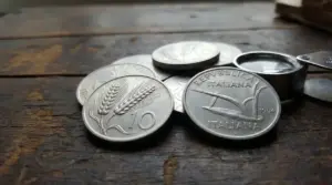 Vecchie monete italiane da 10 lire con spiga su un tavolo di legno